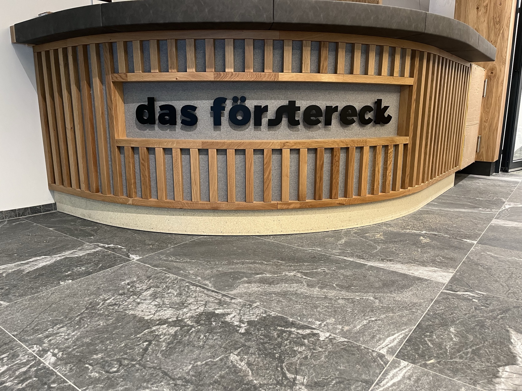 Beleuchteter Firmenschriftzug aus Metall und Holz